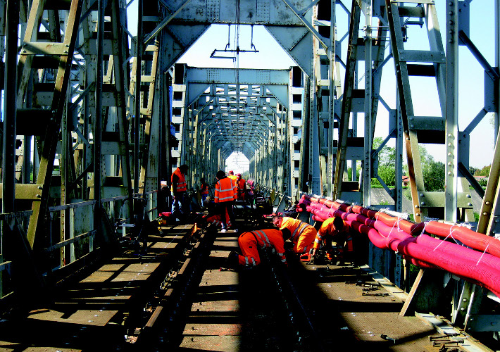 Operai e tecnici delle ferrovie per l'innalzamento del ponte ferroviario